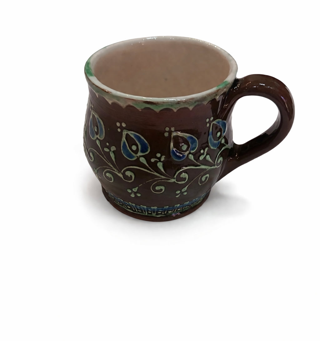 Cană ceramică maro cu motive florale albastre și verzi, lucrată manual